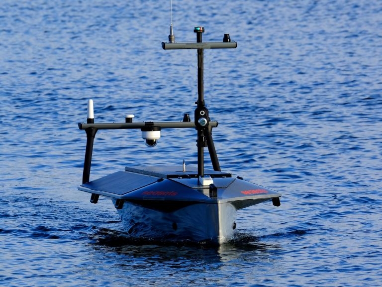 A Seasats Lightfish autonomous surface vehicle moving across water towards the viewer